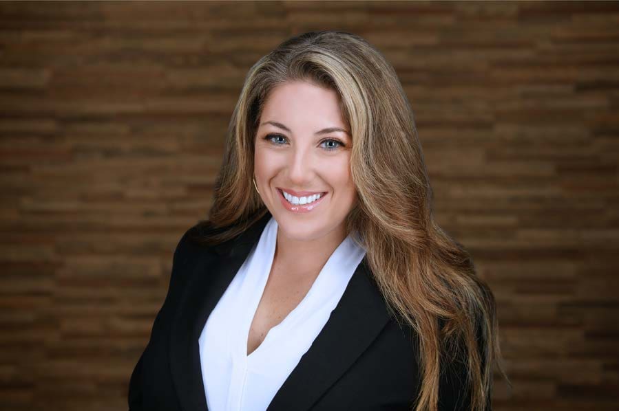 A woman in black jacket smiling for the camera.